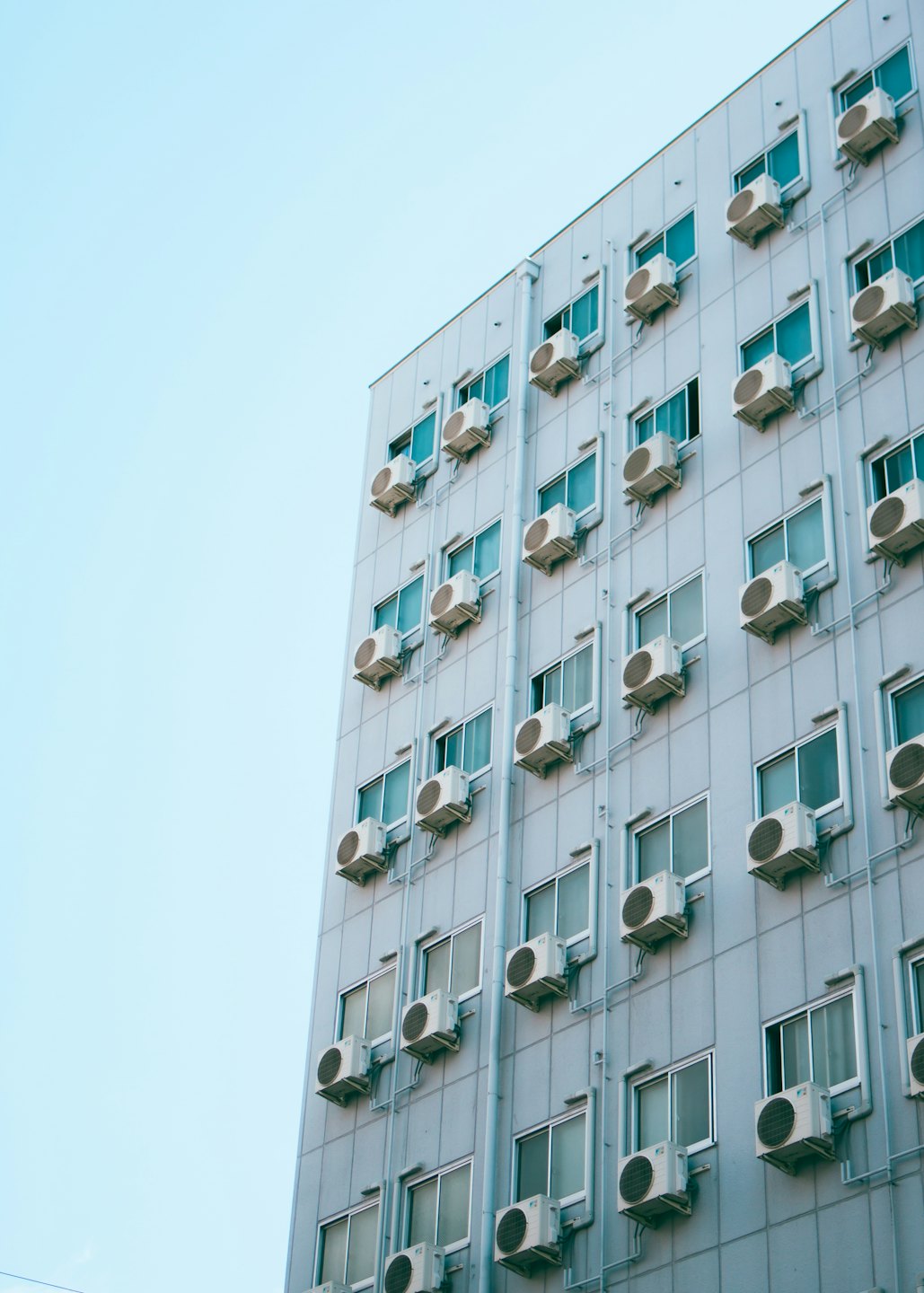 Modern building exterior with rows of air conditioning units.